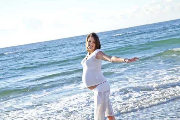 Gyönyörű várandós lány a strandon. — Stock Fotó