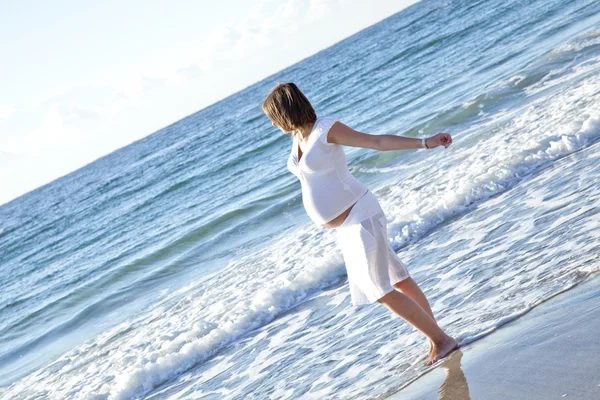 Mooie zwangere meisje op het strand. — Stockfoto