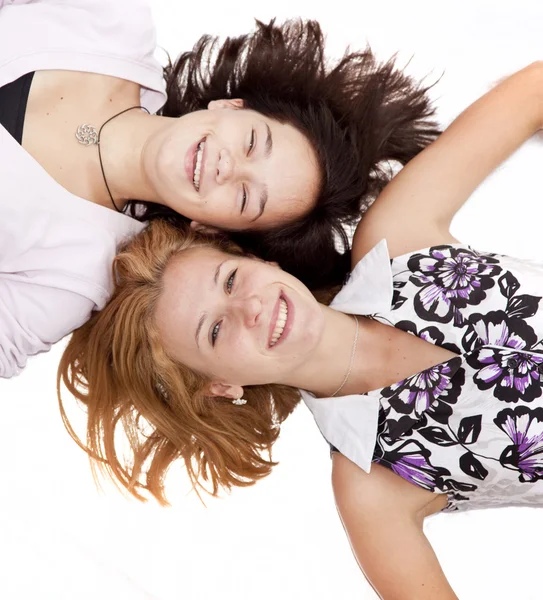Dwie dziewczyny śmieszne leżącego na białym tle. — Zdjęcie stockowe