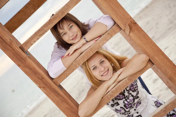 Портрет двух девушек возле деревянных лестниц на пляже . — стоковое фото