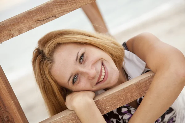 Όμορφη ξανθιά κοπέλα κοντά ξύλινα σκαλοπάτια σε εξωτερικούς χώρους. — Φωτογραφία Αρχείου