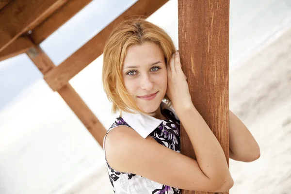 Prachtige blond meisje in de buurt van houten trap van buiten. — Stockfoto