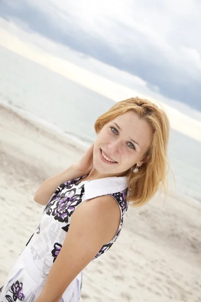 Portret van prachtige blond meisje op het strand. — Stockfoto