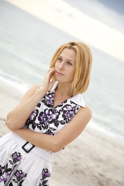 Portret van prachtige blond meisje op het strand. — Stockfoto