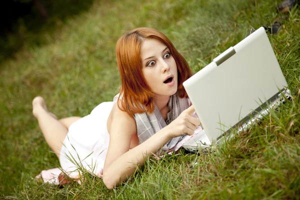 푸른 잔디에 누워 노트북으로 젊은 패션 소녀 — 스톡 사진
