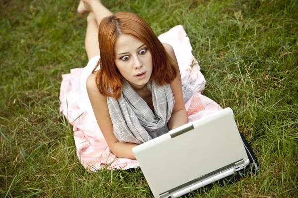 Chica de la moda joven con cuaderno acostado en la hierba verde — Foto de Stock
