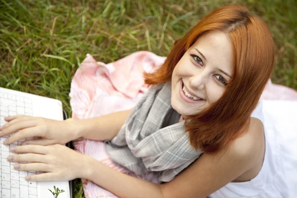 緑の芝生で横になっているノートと若者のファッションの女の子 — ストック写真