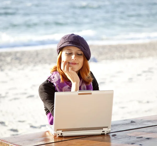 Портрет рыжеволосой девушки с ноутбуком на пляже . — стоковое фото