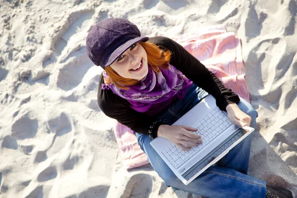 Retrato de muchacha pelirroja con el portátil en la playa. — Stockfoto