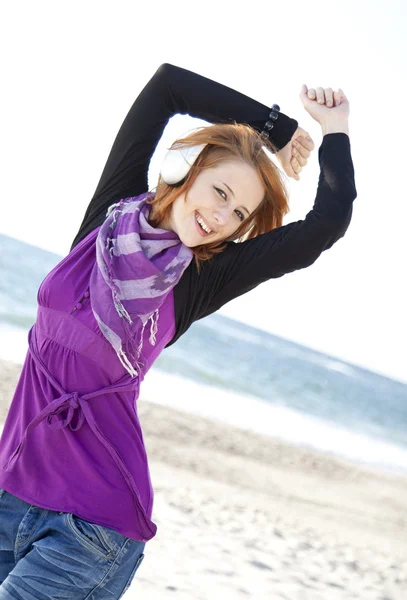 Ritratto di ragazza dai capelli rossi con cuffia sulla spiaggia . — Foto Stock