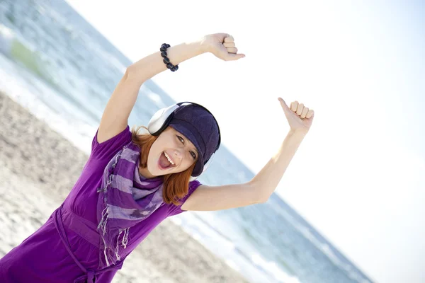Retrato de chica pelirroja con auriculares en la playa . —  Fotos de Stock