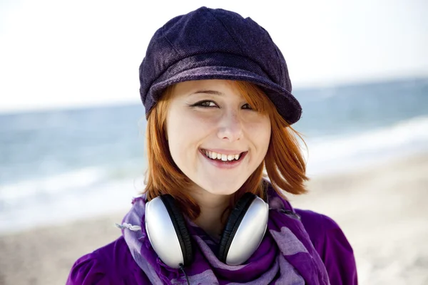 Retrato de chica pelirroja con auriculares en la playa . — Foto de Stock