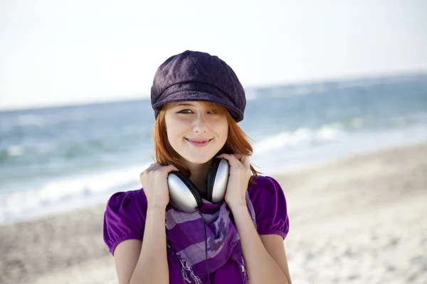 해변에서 헤드폰으로 빨간 머리 여자의 초상화. — 스톡 사진