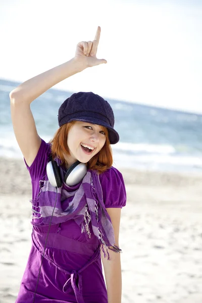 ビーチでヘッドフォンで赤い髪の少女の肖像画. — ストック写真