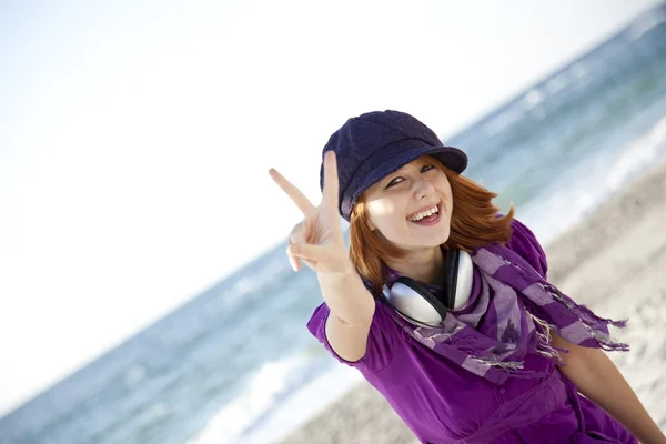 Red-haired girl with headphone on the beach. — Stock Photo, Image