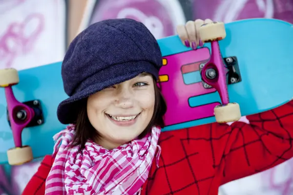 Closeup portrait of a happy young girl with skateboard and graff — Stock Photo, Image