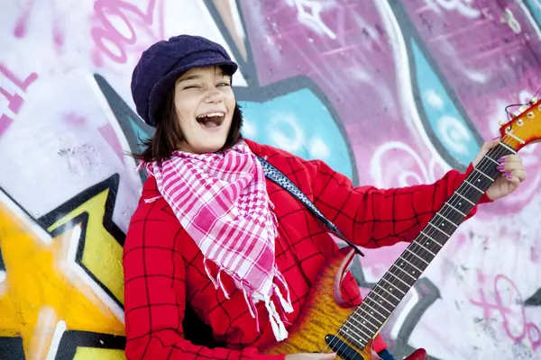 Closeup portrait of a happy young girl with guitar and graffiti — Stock Photo, Image