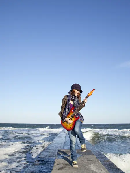 赤い髪の少女再生ギターで風の強い日で. — ストック写真