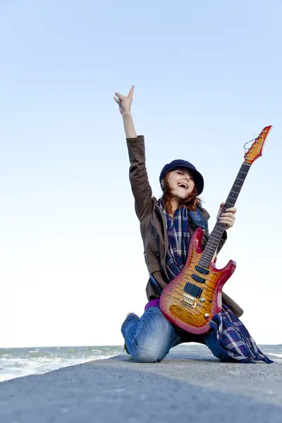 바람이 부는 날에 기타에 빨간 머리 소녀 놀이. — 스톡 사진