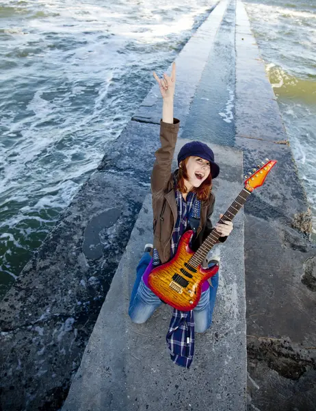 赤い髪の少女再生ギターで風の強い日で. — ストック写真