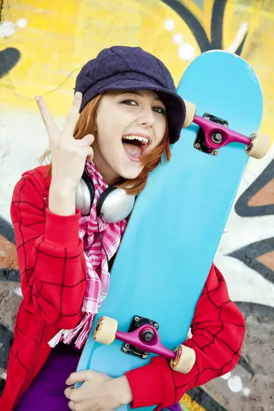 Closeup portrait of a happy young girl with skateboard and graff — Stock Photo, Image