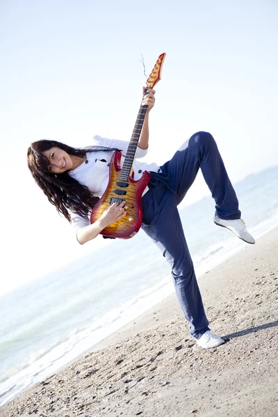 Hübsche junge Frau mit Gitarre am Strand — Stockfoto