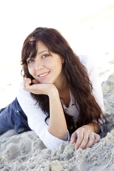 Mujer joven y bonita acostada en la playa — Foto de Stock