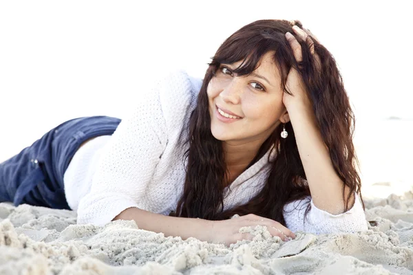 Pretty young woman lying down on beach — Stock Photo, Image
