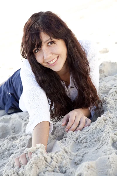 Mujer joven y bonita acostada en la playa — Foto de Stock