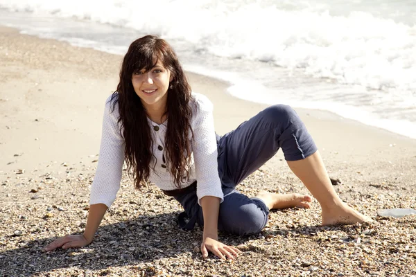Hezká mladá žena s sedí na pláži — Stock fotografie