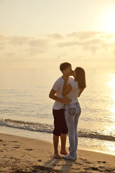 Пара цілується на сході сонця на пляжі . — стокове фото