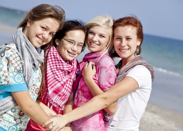 Cuatro amigas abrazadas en la playa . — Foto de Stock