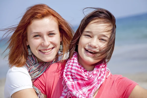 Две обнимающиеся девушки на пляже — стоковое фото