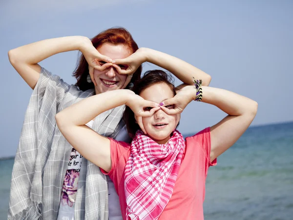 Duas namoradas na praia mostram binocular — Fotografia de Stock