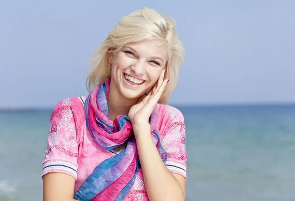 Młoda blondynka w kolorze różowym na plaży. — Zdjęcie stockowe