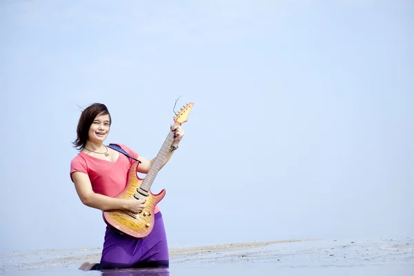 Jeune fille brune avec guitare sur la plage . — Photo