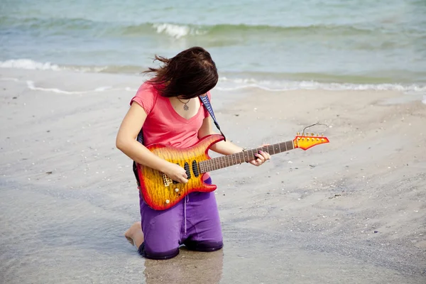 Молода брюнетка дівчина з гітарою на пляжі . — стокове фото