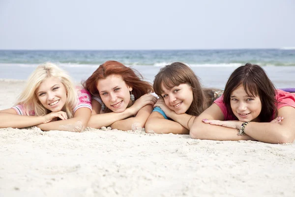 Girlfriends lying down at the beach. — Stock Photo, Image