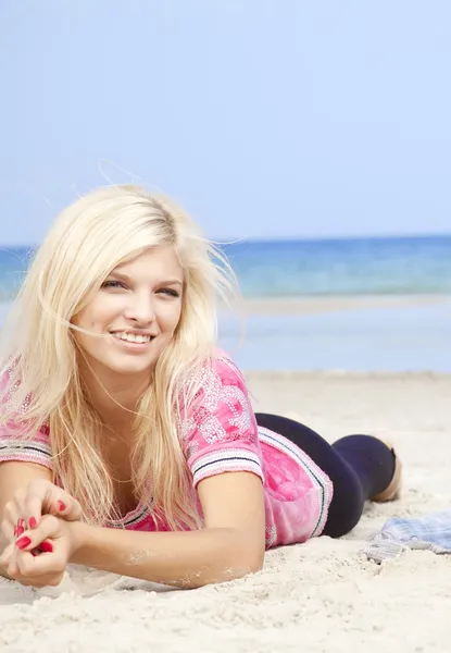 Sexy jeune fille blonde allongée sur la plage . — Photo