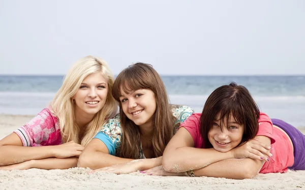 Drie vriendinnen liggen op het strand. — Stockfoto