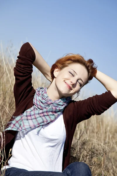 秋の草の上の幸せの赤い髪の少女の肖像画. — ストック写真