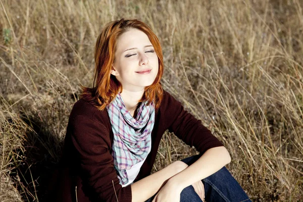 Retrato de menina ruiva feliz na grama do outono . — Fotografia de Stock