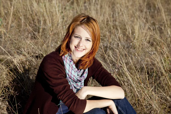 Porträt eines glücklichen rothaarigen Mädchens auf Herbstgras. — Stockfoto