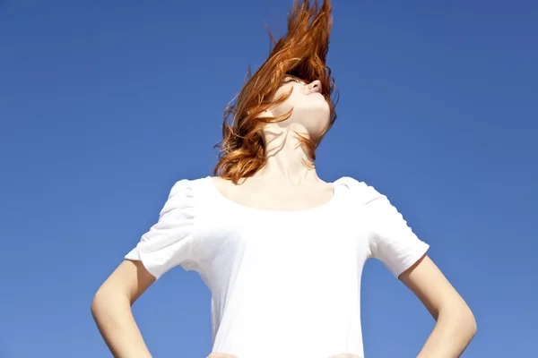 Retrato de menina de cabelos vermelhos em branco no fundo do céu azul . — Fotografia de Stock