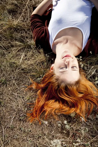 Portret rudowłosej dziewczyny które leżącej na ziemi. — Zdjęcie stockowe