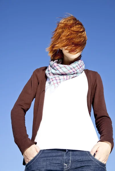 Portrait of red-haired girl with scarf on blue background. — Stock Photo, Image