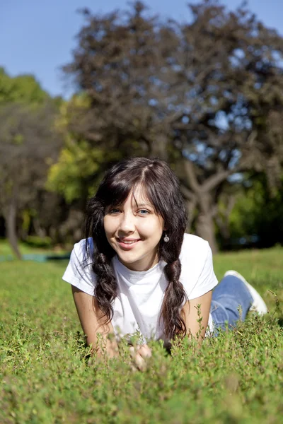 Porträt der schönen brünetten Mädchen mit blauen Augen auf grünem Gras — Stockfoto