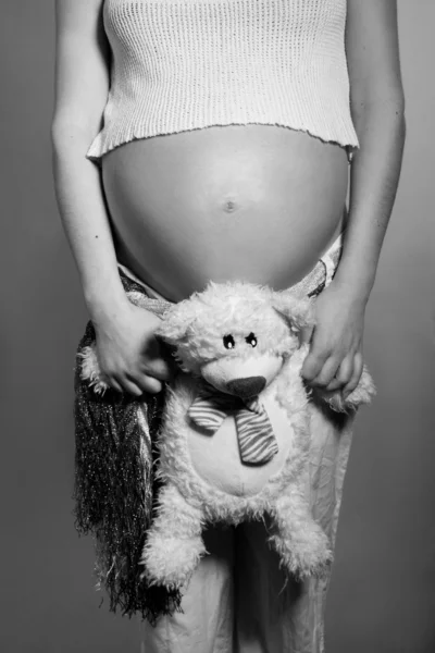 Pregnant belly and sweet teddy bear — Stock Photo, Image