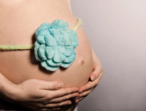 Barriga de mulher grávida com flor — Fotografia de Stock