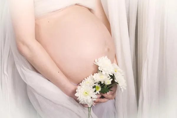 妊娠中の女性の花を持つ — ストック写真